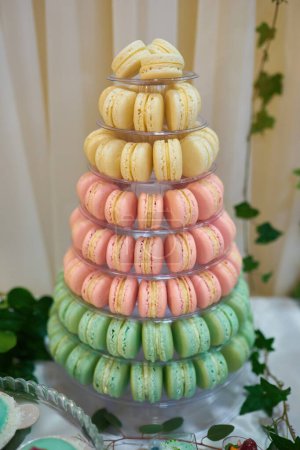 Photo for Macaron tower or pyramid and cupcakes on sweet dessert table - Royalty Free Image