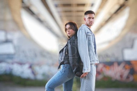 Photo for Stylish and young man and woman posing on the street, a couple deeply in love. - Royalty Free Image
