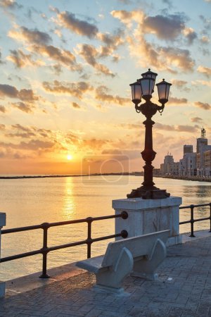 Foto de Frente al mar de Bari. Colorido atardecer increíble. Vista de la costa y de la ciudad. Crepúsculo cielo púrpura y azul
. - Imagen libre de derechos