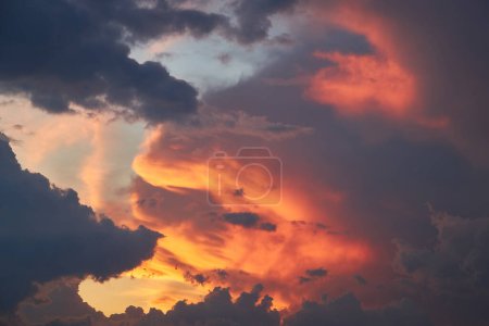 Téléchargez les photos : Un fragment fascinant du ciel, une toile de fond naturelle avec des nuages multicolores aux formes intrigantes éclairées par le soleil couchant, créant une toile à couper le souffle de teintes et de motifs - en image libre de droit
