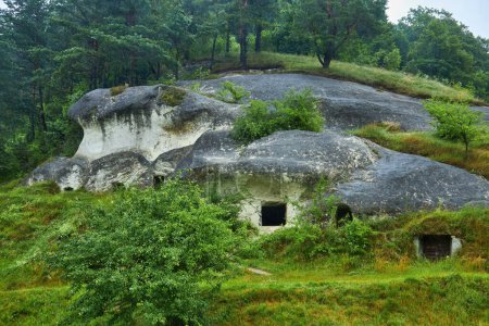 Foto de Grandes casas cueva de edad desde el exterior, tiempo lluvioso - Imagen libre de derechos