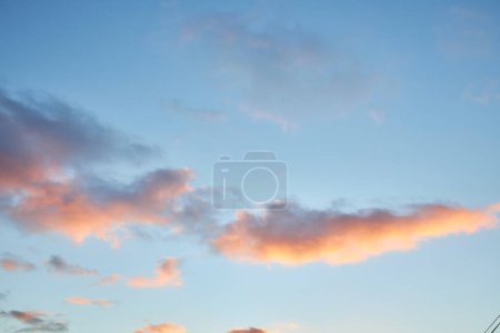Téléchargez les photos : Un fragment fascinant du ciel, une toile de fond naturelle avec des nuages multicolores aux formes intrigantes éclairées par le soleil couchant, créant une toile à couper le souffle de teintes et de motifs - en image libre de droit