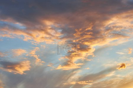 Ein faszinierendes Fragment des Himmels, eine natürliche Kulisse mit bunten Wolken mit faszinierenden Formen, die von der untergehenden Sonne beleuchtet werden und eine atemberaubende Leinwand aus Farben und Mustern schaffen