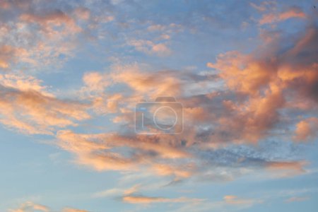 Un fragment fascinant du ciel, une toile de fond naturelle avec des nuages multicolores aux formes intrigantes éclairées par le soleil couchant, créant une toile à couper le souffle de teintes et de motifs