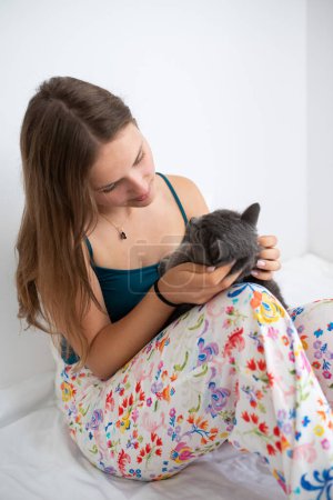 Photo for Young woman taking care of her British shorthair cat - Royalty Free Image