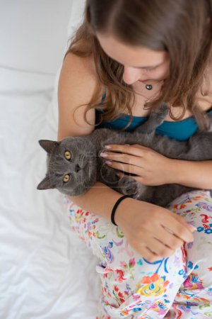 Photo for Young woman gently holding her British shorthair cat like a baby - Royalty Free Image
