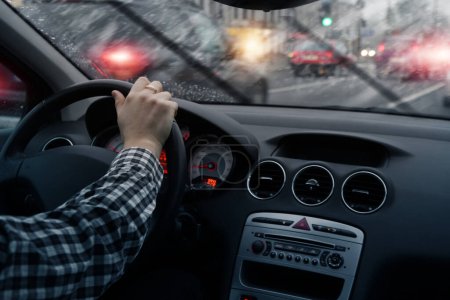 Téléchargez les photos : Driving a car through city streets on a rainy day - en image libre de droit