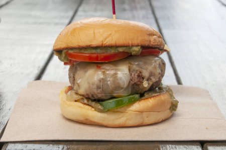 Téléchargez les photos : Délicieux cheeseburger au fromage suisse avec toutes les fixations sur un chignon - en image libre de droit