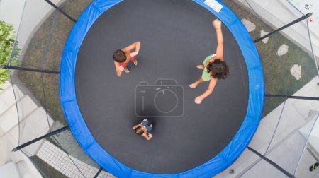 Photo for Children playing on trampoline aerial view together - Royalty Free Image