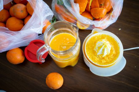 Téléchargez les photos : Été fruits orange frais se pressé dans la cuisine - en image libre de droit