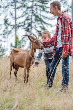 Foto de Niños en el campo rural jugando con cabras de granja. Foto de alta calidad - Imagen libre de derechos