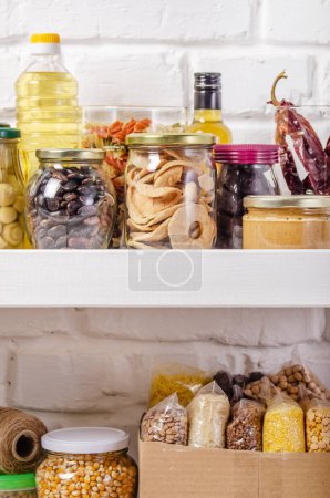 Set von nicht verderblichen Lebensmitteln auf Speisekammer Regal auf Backsteinwand Hintergrund