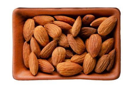Almonds in clay bowl isolated on white flat lay view