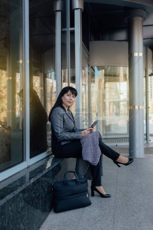 Foto de Mujer de negocios con confianza en la ropa casual y con una computadora portátil en el fondo del centro de negocios. El concepto de trabajar en Internet - Imagen libre de derechos