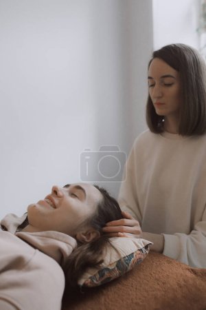 Female energy massage relaxing and care treatment for body and mindfull health gentle woman arms holding head doing access bars and face young procedure. Energetic massage resumes the circulation of energy in body.
