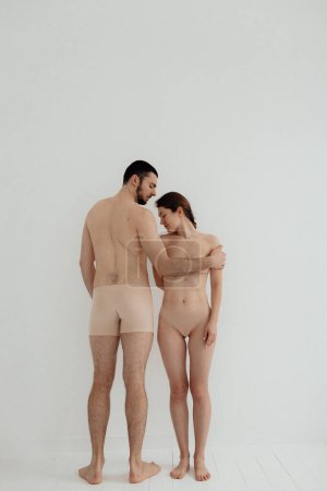 Foto de Cheerful woman and man standing on white background. Body positive young couple of lovers. No focus blurred and noise effect. - Imagen libre de derechos