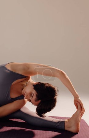 Foto de Mujer joven deportiva haciendo práctica de yoga sobre fondo blanco. concepto de vida sana y equilibrio natural entre el cuerpo y el desarrollo mental. - Imagen libre de derechos