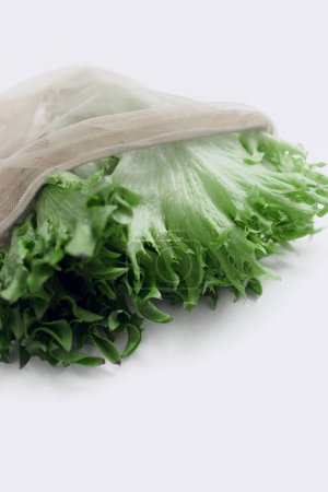 Photo for Raw lettuce from local market in reusable shopping bag over light background. Copy space. Top view. Organic food, edible fresh picked. Plastic Pollution, Ethical Consumerism, Healthy Eating concept. - Royalty Free Image