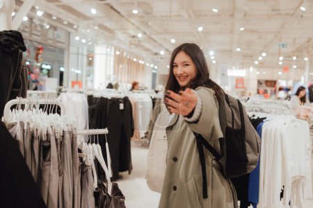 Foto de Chica adolescente coreana elegir y comprar ropa de moda en un centro comercial. Retail y consumismo. Promoción de venta y concepto de compras. Parte de una serie. - Imagen libre de derechos