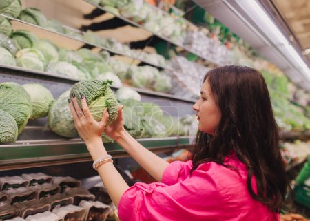 Foto de Mujer coreana joven comprando sin bolsas de plástico en la tienda de comestibles. Chica vegana de cero residuos eligiendo frutas y verduras frescas en el supermercado. Parte de una serie. - Imagen libre de derechos