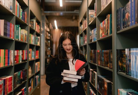 Foto de Pretty teen gen Z Chica estudiante coreana elige libro en una librería. Concepto de formación educativa. Parte de una serie. - Imagen libre de derechos
