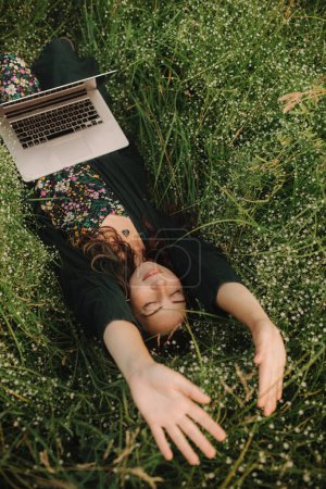 Mujer usando laptop en IT afuera en eco-granja. Charla en línea. Pase tiempo libre en la naturaleza. Concepto de trabajo desde casa, vida lenta, mantenerse conectado, distanciamiento social, internet. Parte de la serie.
