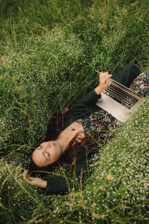 Frau benutzt Laptop in IT draußen in Öko-Bauernhof. Online-Chat. Verbringen Sie Ihre Freizeit in der Natur. Konzept Arbeiten von zu Hause aus, langsames Leben, Vernetzung, soziale Distanzierung, Internet. Teil der Serie.