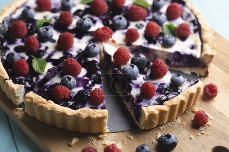 berry pie with raspberries and blueberries on a blue backgroun