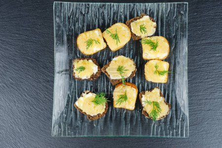 Foto de Piezas de pan con delicioso caviar de bacalao sobre fondo de pizarra de piedra negra - Imagen libre de derechos