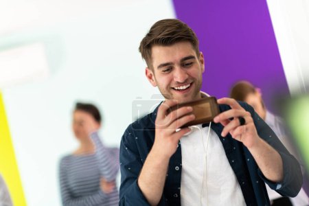 Photo for Diverse teenagers using mobile devices while posing for a studio photo in front of a colorful background. High quality photo - Royalty Free Image