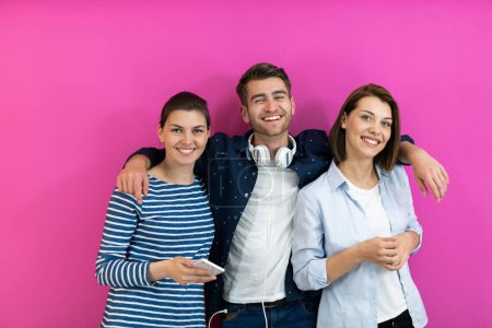 Téléchargez les photos : Groupe de jeunes en vêtements modernes posant et s'amusant isolés devant fond rose. Photo de haute qualité - en image libre de droit
