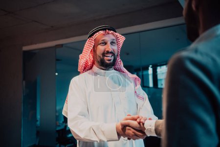 Foto de Un anciano árabe estrechando la mano de un hombre de negocios y terminando una reunión de negocios con negocios exitosos. Foto de alta calidad - Imagen libre de derechos