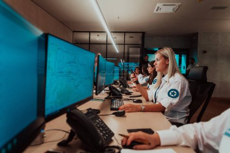 Foto de Group of female security operators working in a data system control room Technical Operators Working at the workstation with multiple displays, security guards working on multiple monitors in - Imagen libre de derechos