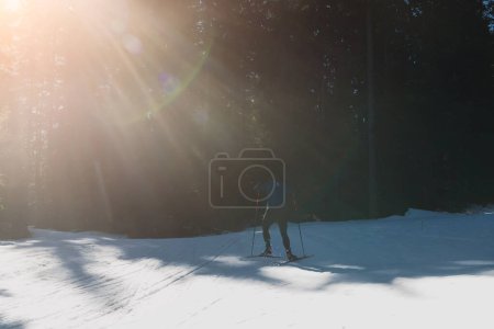 Foto de Esquí nórdico o esquí de fondo técnica clásica practicada por el hombre en un hermoso sendero panorámico por la mañana. Foto de alta calidad - Imagen libre de derechos