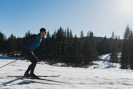 Téléchargez les photos : Ski nordique ou ski de fond technique classique pratiquée par l'homme dans un magnifique sentier panoramique le matin. Photo de haute qualité - en image libre de droit
