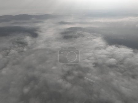 Foto de Imágenes aéreas de aviones no tripulados de niebla brumosa soplando sobre el bosque de pinos en una hermosa mañana. Imágenes aéreas de árboles de abetos en las colinas de las montañas. Copiar el espacio fondo natural. Hola calidad 4K video - Imagen libre de derechos