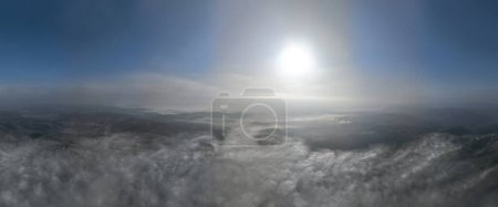 Téléchargez les photos : Images aériennes de drones de brouillard brumeux soufflant sur la forêt de pins par une belle matinée. Images aériennes d'épinettes sur les collines montagneuses. Espace de copie arrière-plan naturel. Salut qualité vidéo 4K - en image libre de droit