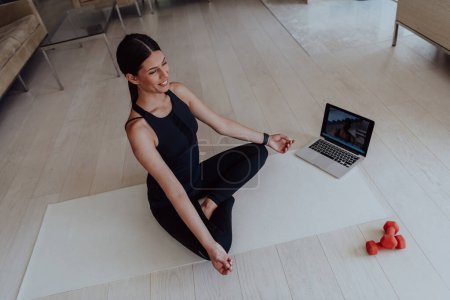 Photo for Young Beautiful Female Exercising, Stretching and Practising Yoga with Trainer via Video Call Conference in Bright Sunny House. Healthy Lifestyle, Wellbeing and Mindfulness Concept. - Royalty Free Image