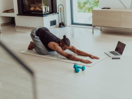 Photo for Training At Home. Sporty man doing the training while watching an online tutorial on a laptop, exercising in the living room, free space. - Royalty Free Image