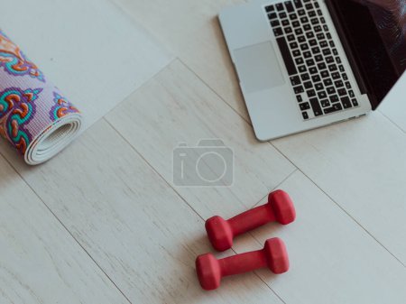 Photo for Photo of a laptop, dumbbells and headphones on the floor of the living room. Online training concept. High quality photo - Royalty Free Image