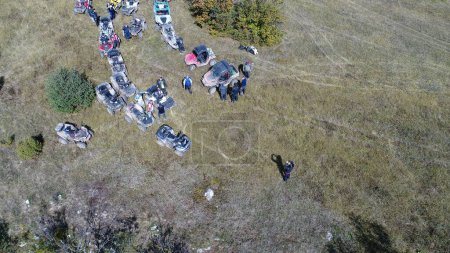 Foto de Vista aérea de aviones no tripulados de quads ATV en un sendero de tierra en los bosques. Los entusiastas del club de grupo fuera de carretera se divierten mientras conducen carreteras rurales. Imágenes de alta calidad 4k - Imagen libre de derechos