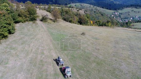 Téléchargez les photos : Vue aérienne par drone des quads de VTT sur un sentier de terre dans les forêts. Les passionnés de club d'équipe hors route s'amusent en conduisant des routes de campagne. Images 4k de haute qualité - en image libre de droit