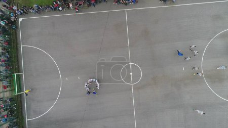 Téléchargez les photos : Vue de dessus drone volant au-dessus de match de football amateur. Tournoi authentique de campagne. Images 4k de haute qualité - en image libre de droit