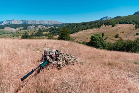 Foto de Soldado del ejército sosteniendo rifle de francotirador con mira y apuntando en el bosque. Guerra, ejército, tecnología y concepto de personas. - Imagen libre de derechos