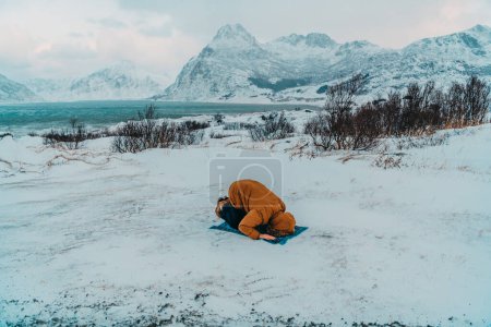 Téléchargez les photos : Un musulman voyageant à travers les régions froides arctiques tout en effectuant la prière musulmane namaz pendant les pauses. - en image libre de droit
