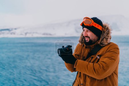 Téléchargez les photos : Un photographe dans les régions froides de Skavdinava tente de prendre une photo pour le journalisme dans une forte tempête hivernale. - en image libre de droit