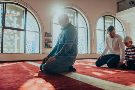 Foto de Un grupo de musulmanes en una mezquita moderna rezando la oración musulmana namaz, durante el mes sagrado del Ramadán. - Imagen libre de derechos
