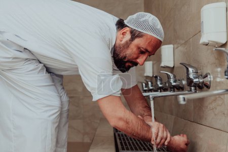 Téléchargez les photos : Un musulman pratiquant l'ablution. Nettoyage religieux rituel des musulmans avant d'effectuer la prière. Le processus de purification du corps avant la prière. - en image libre de droit
