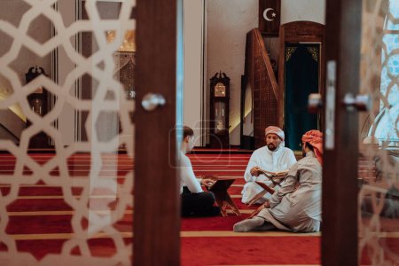A group of Muslims reading the holy book of the Quran in a modern mosque during the Muslim holiday of Ramadan. 