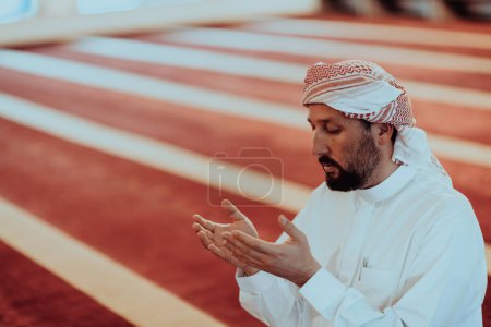 Téléchargez les photos : Arabe musulman priant. Homme musulman religieux priant à l'intérieur de la mosquée pendant le ramadan. Photo de haute qualité - en image libre de droit